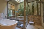 Spacious master bath with soaking tub and a shower that opens to a calming outdoor stepping fountain